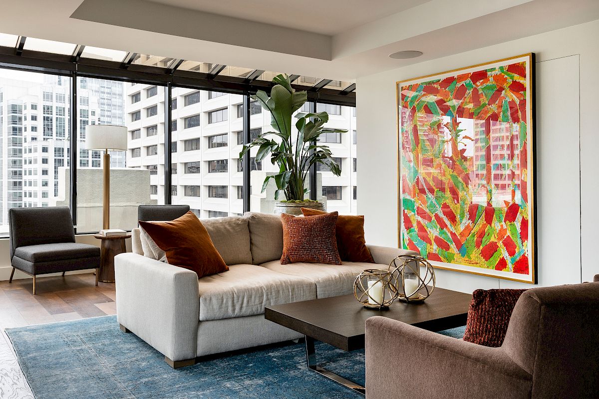 A modern living room with a city view features a sofa, colorful artwork, indoor plants, and chic furniture, ending the sentence.