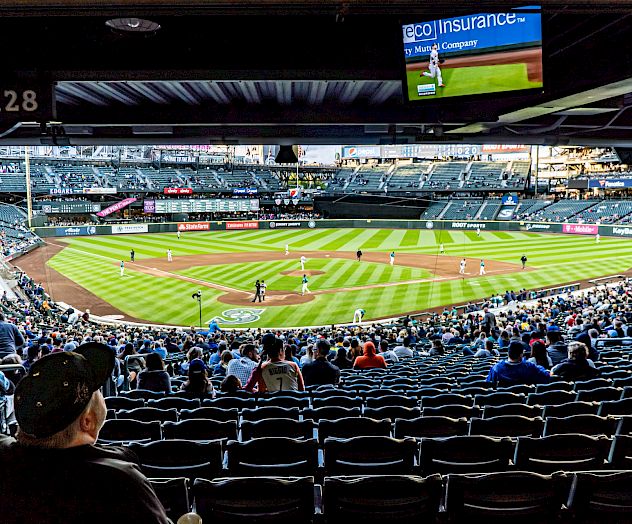 The image shows a baseball game being played in a large stadium with spectators watching from the stands.