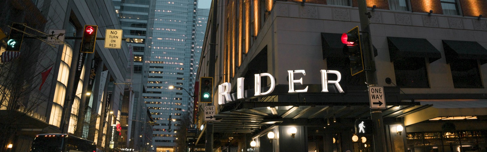 City street with tall buildings, including one with a sign 