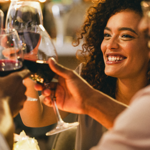 Friends toasting with wine glasses, smiling and enjoying a cheerful moment together.